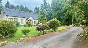 a white house with a road in front of it at The Tranquil Retreat Countryside Escape in Larkhall