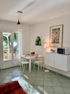 a kitchen and dining room with a table and a microwave at Colibrì by SolturElba in Capoliveri