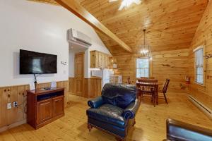 a living room with a leather chair and a table at Comfortable two bedroom cabin with firepit, kitchen, hiking trail within walking in Northport