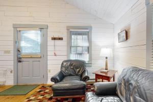 a living room with a leather chair and a table at Charming dog-friendly studio cabin with firepit and near outdoor fun in Northport +58 photos