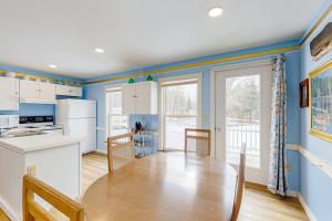 a kitchen with blue walls and a wooden table and a kitchen with a tablektop at Colorful duplex home with a large yard, deck, WiFi, & ideal Midcoast location in Boothbay +21 photos