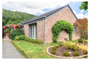 a brick house with a garden in front of it at L'Aurore Céleste in Aywaille