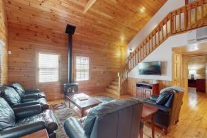 a living room with leather couches and a fireplace at Charming dog-friendly studio cabin with firepit and near outdoor fun in Northport