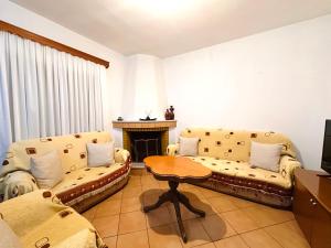a living room with two couches and a table at Cozy Village Guesthouse in Delvinë