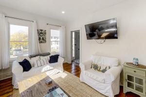 a living room with two white couches and a flat screen tv at Coastal home with new, full kitchen, walkable downtown location in Boothbay Harbor