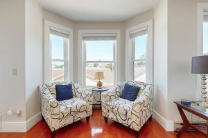 two chairs and a table in a room with windows at Admiral's Quarters in Boothbay Harbor