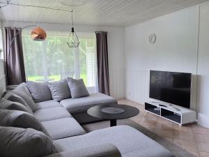 a living room with a couch and a flat screen tv at Fjordside Apartment in Åndalsnes
