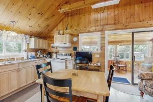 a kitchen and dining room with a wooden ceiling at Lakefront, cabin-inspired home with firepit, grill, & screened porch, Wifi in Greenville +17 photos
