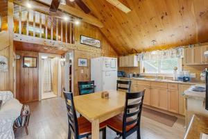 a kitchen and dining room with a table and chairs at Lakefront, cabin-inspired home with firepit, grill, & screened porch, Wifi in Greenville