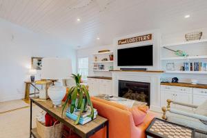 a living room with a fireplace and a tv at Perfectly Located Retreat with Grill, Fireplace, & Chef in Boothbay Harbor
