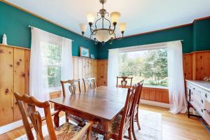 a dining room with a wooden table and chairs at Coastal Serenity Retreat with Ocean Views, Spacious Porch and Modern Comforts in Sullivan