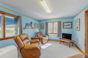 a living room with a couch and a chair at Charming, single-level getaway with a full kitchen, fast WiFi, & grassy yard in Boothbay
