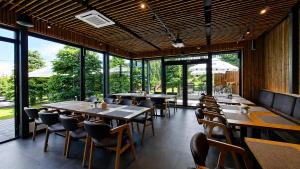 a restaurant with wooden tables and chairs and windows at Pensiune & Restaurant Victoria in Păltiniş