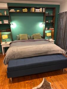 a bedroom with a large bed with a green wall at Bamboo in George