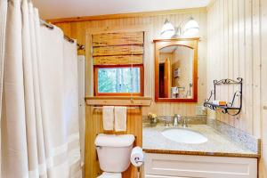 a bathroom with a toilet and a sink at Dog-friendly 3-story home with wood stove, deck, grill, ocean views, W/D, AC in Southwest Harbor +28 photos