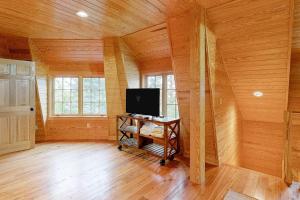a living room with a tv and a wooden wall at Spectacular oceanfront retreat with amazing views, sunroom & washer/dryer in Georgetown