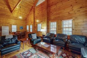 a living room with leather furniture and a table at Charming dog-friendly studio cabin with firepit and near outdoor fun in Northport