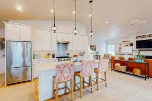 a kitchen with white cabinets and a island with bar stools at Perfectly Located Retreat with Grill, Fireplace, & Chef in Boothbay Harbor +20 photos