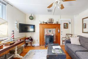 a living room with a couch and a fireplace at Historic Boothbay Harbor cottage with antique decor, washer/dryer & deck in Boothbay Harbor