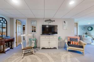 a living room with a flat screen tv and a couch at Oceanfront home with dock, beautiful deck & firepit - steps to the beach in Harpswell Center