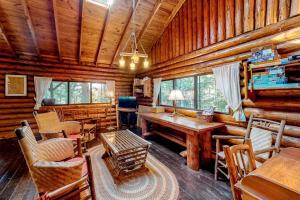 a living room with a table and chairs in a log cabin at Stunning log cabin with fireplace & nature views - near shopping & dining in Boothbay Harbor