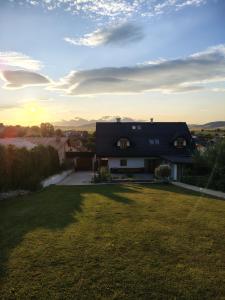 a house with a large yard with the sunset in the background at D.A.R. - Slovenský Raj in Letanovce