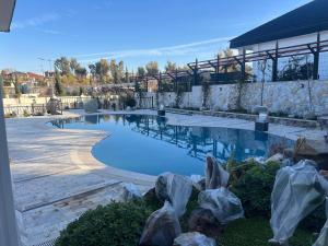 a large swimming pool with chairs in a yard at Hemin's Greenery Villa in Erbil
