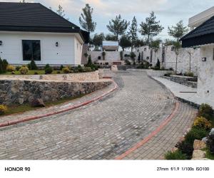 a cobblestone driveway in front of a house at Hemin's Greenery Villa in Erbil