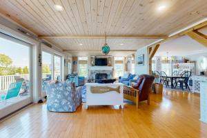 a living room with a couch and chairs at Oceanfront home with dock, beautiful deck & firepit - steps to the beach in Harpswell Center +36 photos