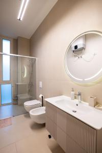 a bathroom with a sink and a toilet and a mirror at Kalpazo White Stones in Palasë +55 photos