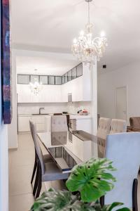 a dining room with a table and chairs and a chandelier at Kalpazo White Stones in Palasë