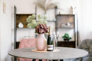 a table with a bottle of champagne and a vase with flowers at Fövenyes Hideaway in Balatonudvari
