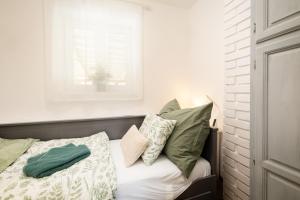 a bedroom with a bed with pillows and a window at Fövenyes Hideaway in Balatonudvari