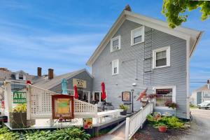 a large gray house with a white porch at Charming, historic cottage with modern upgrades - stroll to dining & attractions in Boothbay Harbor