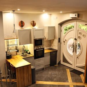 a kitchen with white cabinets and a large window at The Tranquil Retreat Countryside Escape in Larkhall