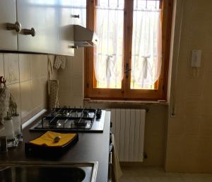 Una cocina con estufa, fregadero y ventana. en Villa Anna, en Savelletri di Fasano