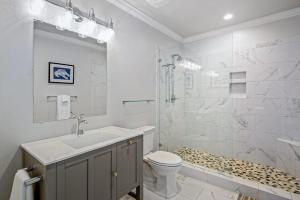 a bathroom with a sink and a toilet and a shower at Waterfront Duplex, walkable, harbor views, AC, dog friendly in Camden +21 photos