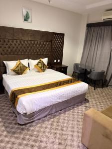 a hotel room with a large bed and a chair at Nilufer AlHada Hotel - فندق نيلوفر الهدا in Taif