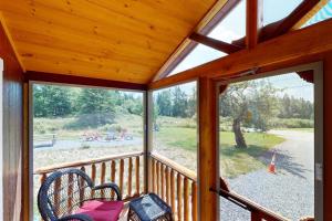 a screened in porch with two chairs and a table at Cozy Cabin with Ocean and Mountain Views, Free Internet in Sullivan