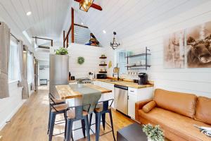a kitchen and living room with a couch and a table at Brand-new dog-friendly home near Hancock Pond with firepit, grill, streaming, AC in Bucksport