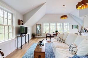 a living room with a white couch and a table at Brand new guest apartment with furnished deck, fast WIFI, dock, & water views in Boothbay Harbor