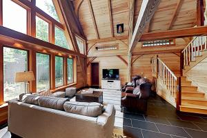 a living room with a couch and chairs in a cabin at 2 beautifully designed, off-the-grid homes with amazing lakefront views & access in Franklin