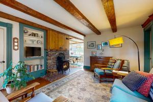 a living room with a couch and a fireplace at Charming Seaside Cottage with a Gas Fireplace, Spacious Patio, and Nearby Hiking in Hancock