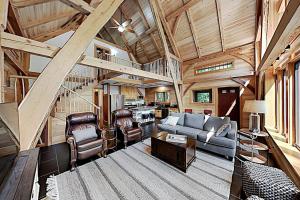 a living room filled with furniture and a wooden ceiling at 2 beautifully designed, off-the-grid homes with amazing lakefront views & access in Franklin