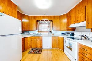 a kitchen with wooden cabinets and a white refrigerator at Waterfront home with beautiful bay views - near shops & dining in Owls Head