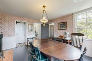 a dining room with a wooden table and chairs at Historic riverfront home with boathouse & private dock - dogs OK in Boothbay
