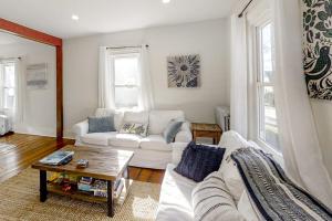 a living room with a white couch and a table at Coastal home with new, full kitchen, walkable downtown location in Boothbay Harbor