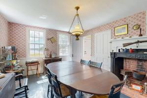 a dining room with a table and a fireplace at Historic riverfront home with boathouse & private dock - dogs OK in Boothbay +17 photos