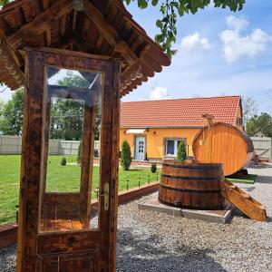 a wooden door with a wooden barrel in front of a house at Déjá-Vu Apartmanház in Szigetvár