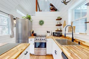 a kitchen with a stove and a sink at Brand-new dog-friendly home near Hancock Pond with firepit, grill, streaming, AC in Bucksport